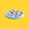 Comedero lento interactivo ANIMALZO con rompecabezas circular en tonos azul, rosa y beige sobre fondo amarillo