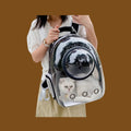 Mochila transportadora ANIMALZO tipo cápsula espacial con ventana panorámica transparente y gato blanco en el interior