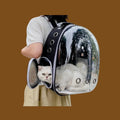 Mochila transportadora ANIMALZO tipo cápsula espacial negra con ventana panorámica transparente y gato blanco dentro