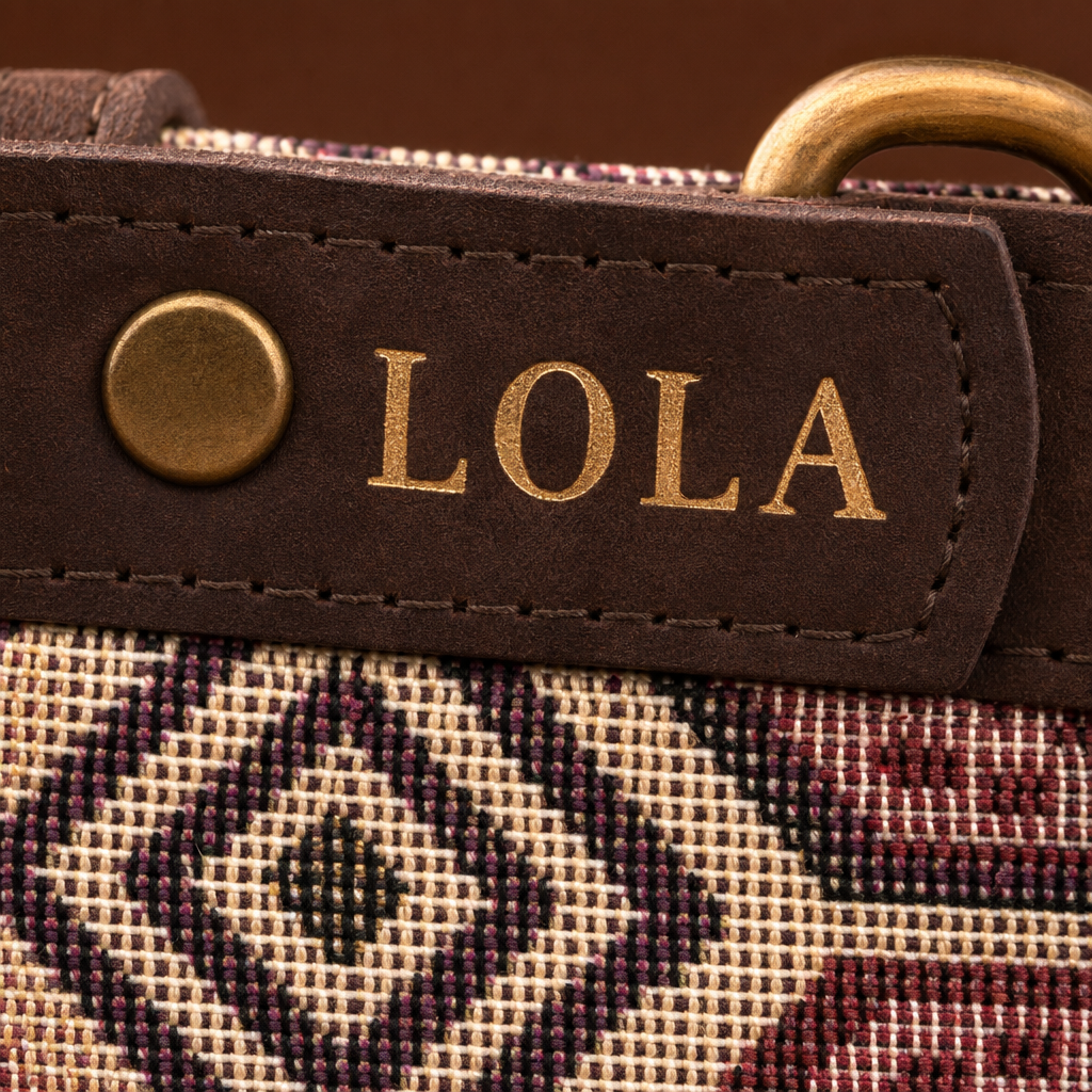 Detalle del collar Sierra: nombre LOLA grabado en oro sobre el cuero y tela etnica